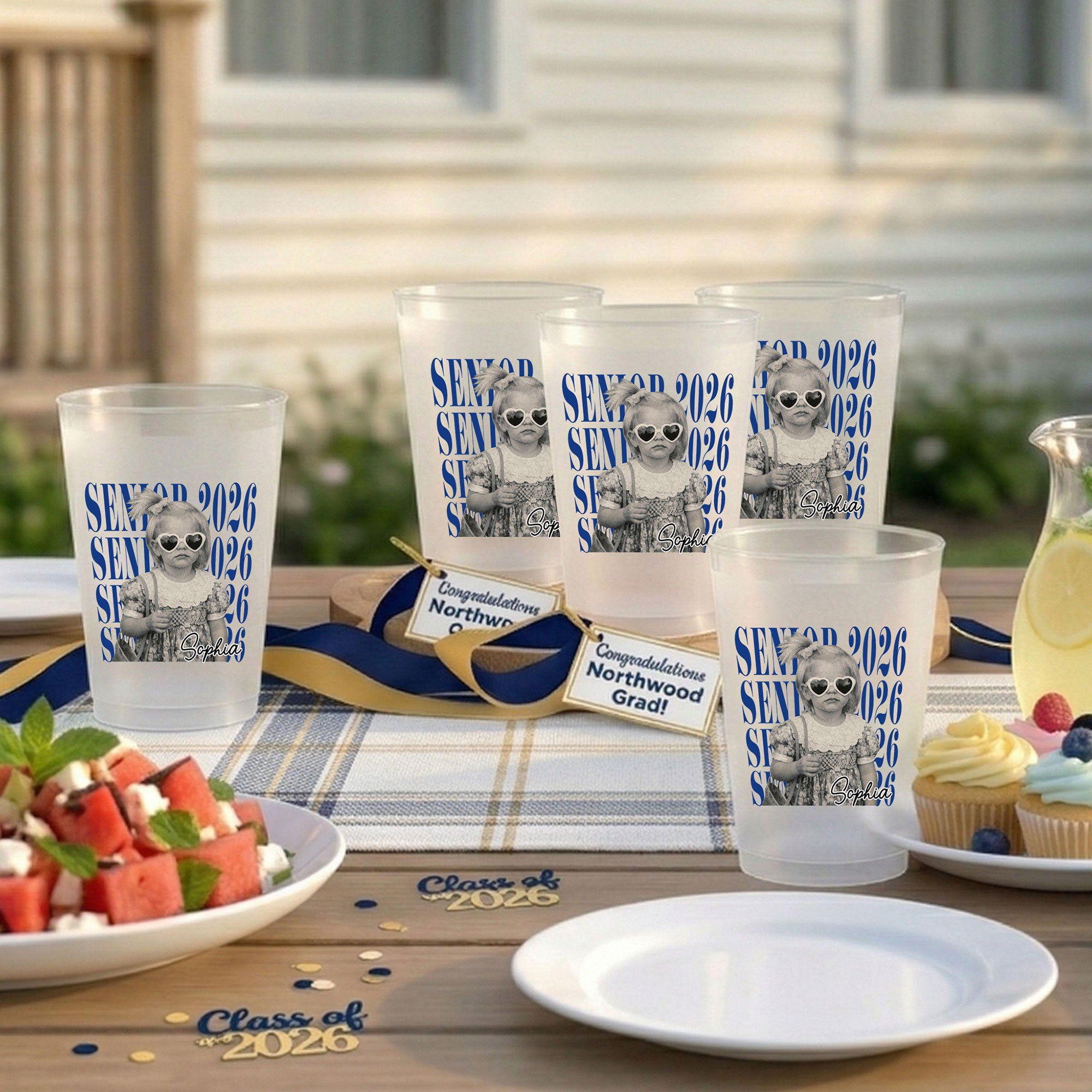 Personalized graduation gifts arranged on a styled surface — tassel charms, jewelry dishes, custom shirts